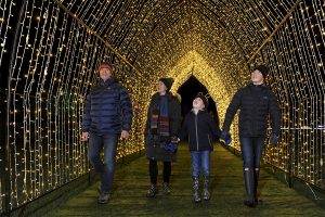 Family walking through illuminated arch at Malvern Winter Glow